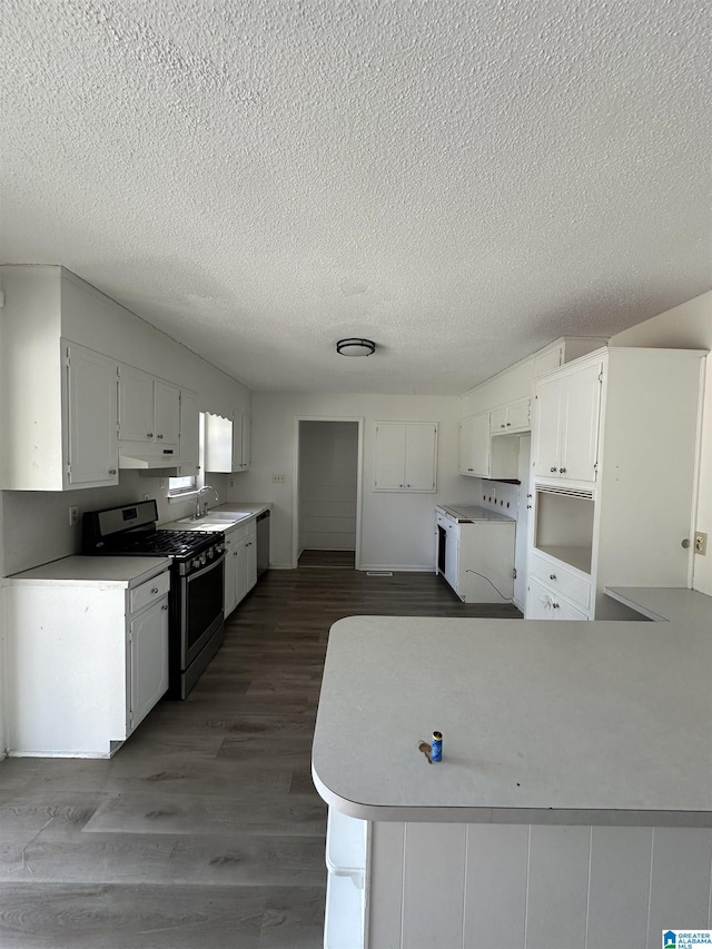 kitchen featuring white cabinetry, appliances with stainless steel finishes, kitchen peninsula, and sink