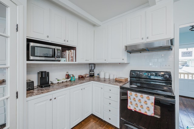 kitchen featuring dark wood-type flooring, tasteful backsplash, white cabinets, dark stone countertops, and black electric range