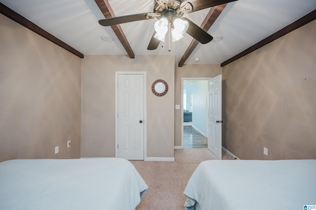 carpeted bedroom with ceiling fan and beam ceiling