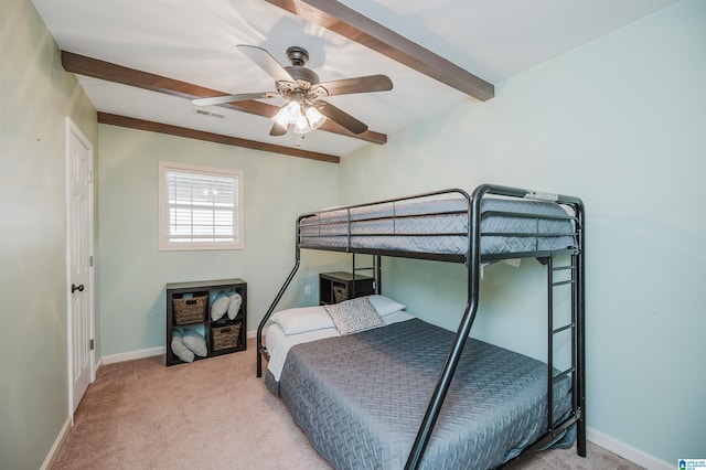 carpeted bedroom with ceiling fan and beamed ceiling