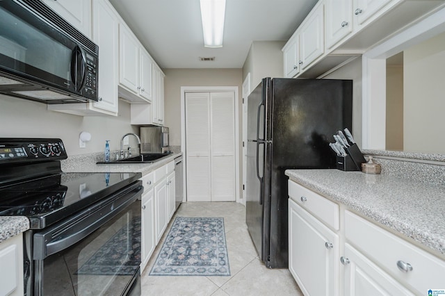 kitchen featuring black appliances, white cabinetry, sink, and light tile patterned floors