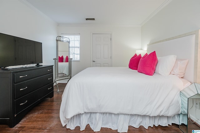 bedroom with dark hardwood / wood-style flooring and ornamental molding