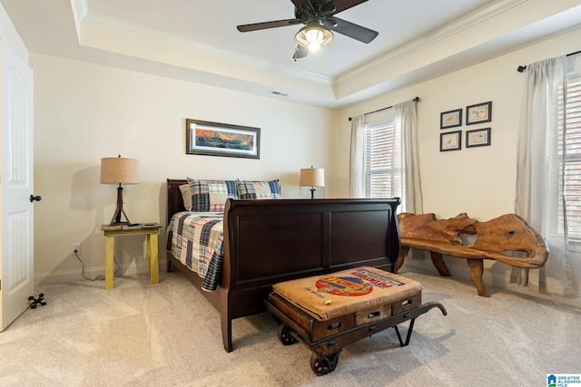 carpeted bedroom featuring ceiling fan and a tray ceiling