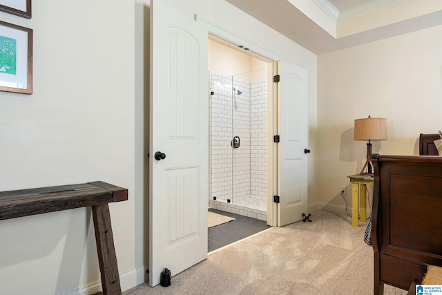 bathroom with a shower with door and crown molding