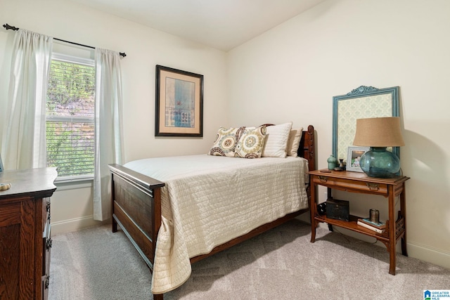 bedroom featuring light colored carpet and multiple windows