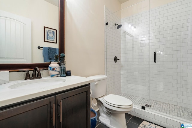 bathroom featuring walk in shower, vanity, tile patterned floors, and toilet