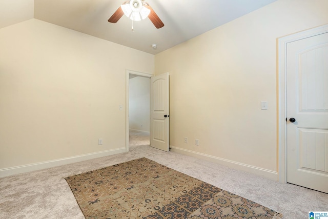 carpeted empty room with ceiling fan and lofted ceiling