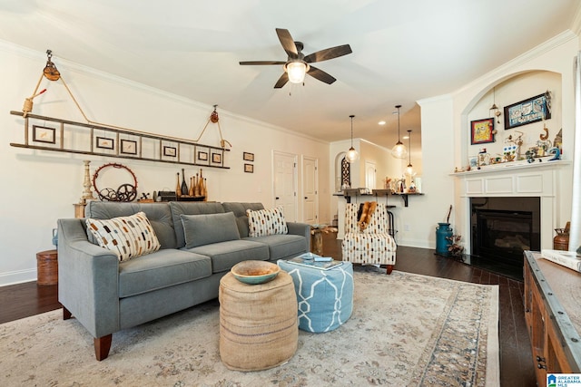 living room featuring ceiling fan, dark wood-type flooring, and ornamental molding