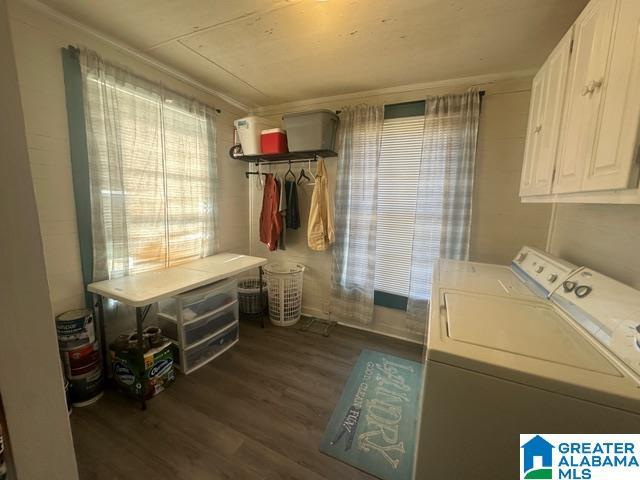 clothes washing area with cabinets, ornamental molding, dark wood-type flooring, and washing machine and clothes dryer