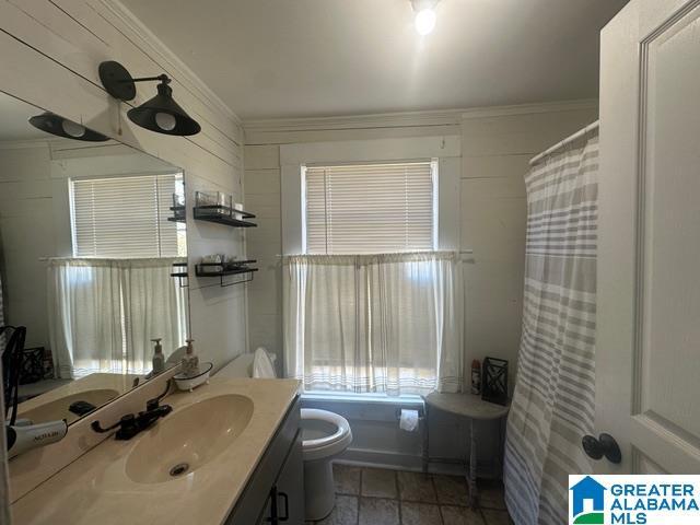 bathroom with vanity, toilet, and ornamental molding