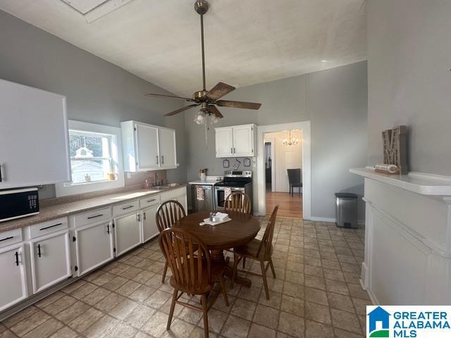 kitchen with white cabinets, sink, vaulted ceiling, electric range, and ceiling fan