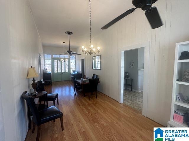 dining room featuring hardwood / wood-style flooring and ceiling fan with notable chandelier