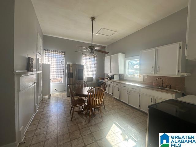 kitchen featuring white cabinets, ceiling fan, sink, and stainless steel refrigerator with ice dispenser