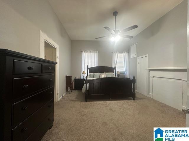 bedroom with ceiling fan, light carpet, and vaulted ceiling