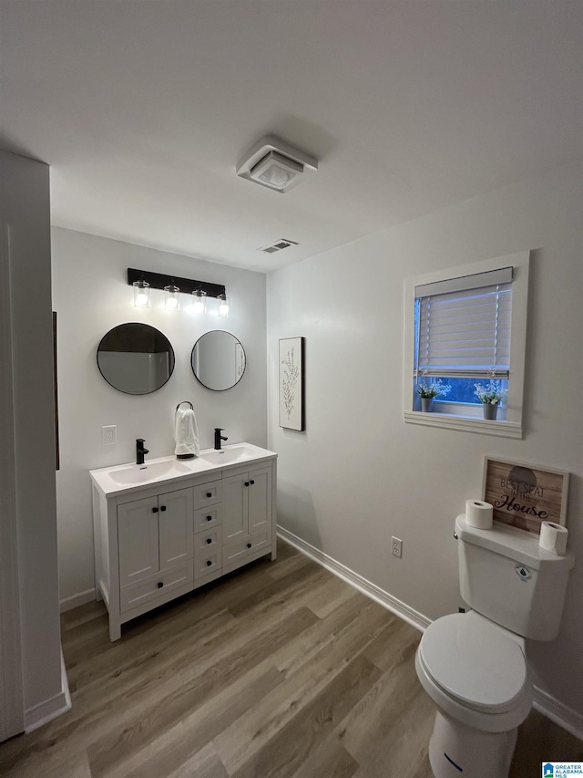 bathroom with toilet, wood-type flooring, and vanity