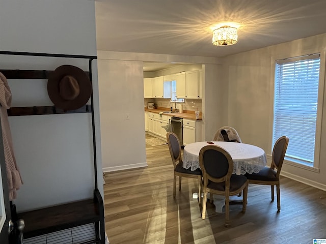 dining room with a chandelier, light hardwood / wood-style flooring, and sink