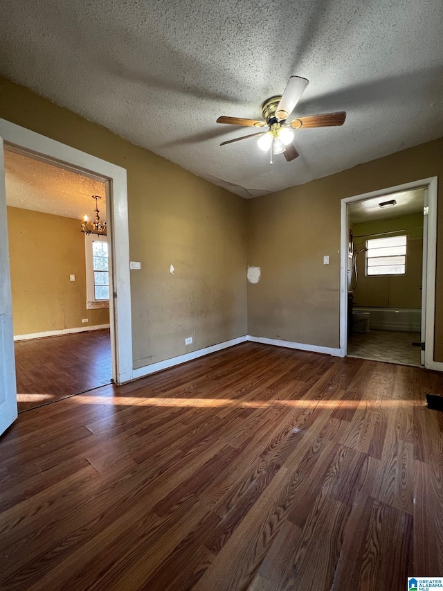 spare room with a healthy amount of sunlight, dark wood-type flooring, and a textured ceiling