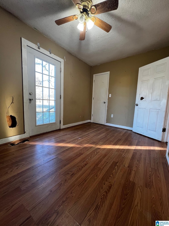 spare room with ceiling fan, dark hardwood / wood-style flooring, and a textured ceiling