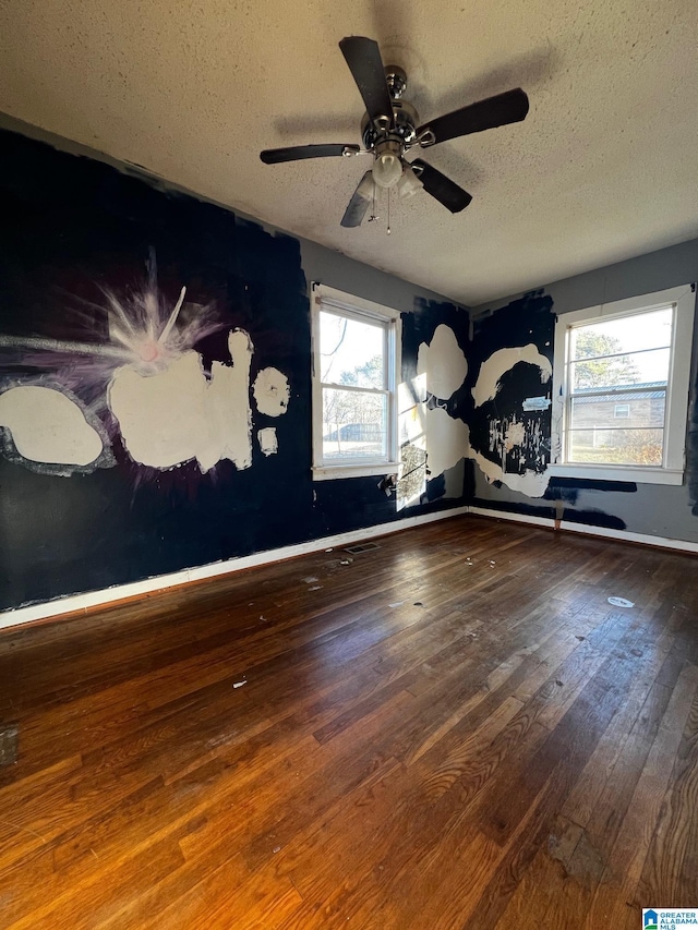 empty room featuring a textured ceiling and hardwood / wood-style floors