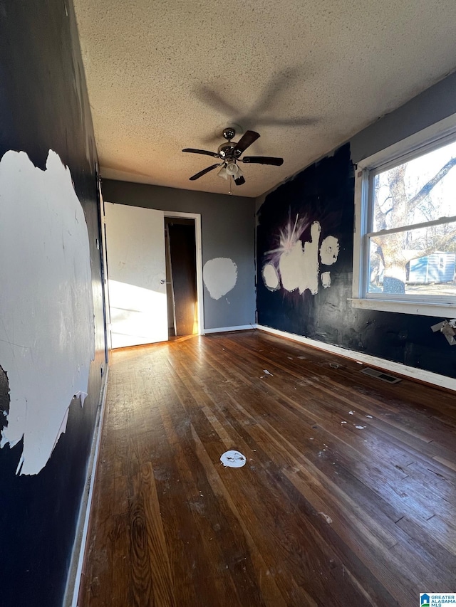 unfurnished bedroom with ceiling fan, a textured ceiling, and wood-type flooring