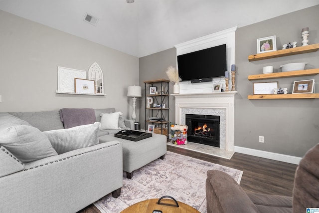 living room with a high end fireplace and hardwood / wood-style floors