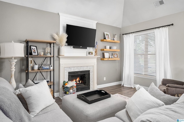 living room featuring dark hardwood / wood-style floors, a large fireplace, and vaulted ceiling