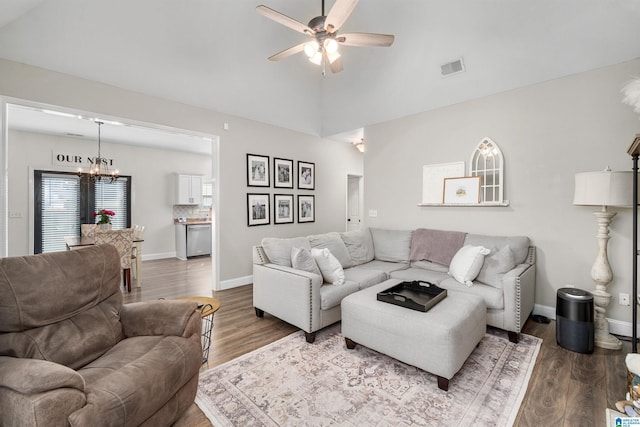 living room featuring lofted ceiling, wood-type flooring, and ceiling fan with notable chandelier