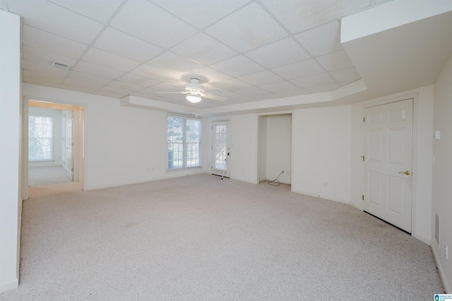 unfurnished room featuring light colored carpet, a drop ceiling, and ceiling fan