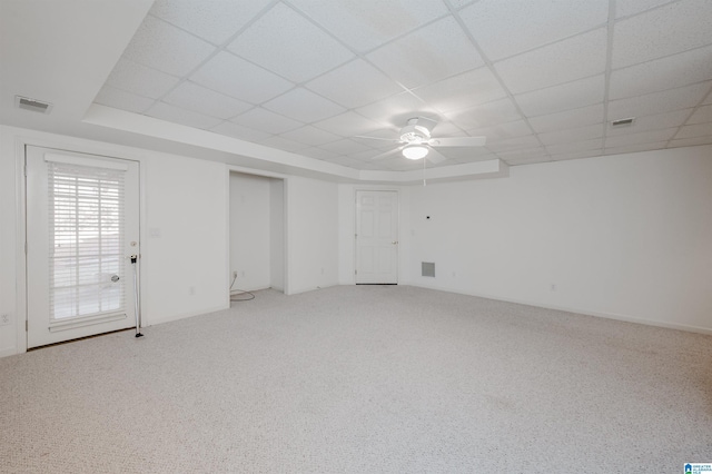 empty room featuring carpet flooring, ceiling fan, and a drop ceiling