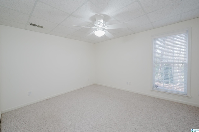 spare room with carpet, a drop ceiling, and plenty of natural light