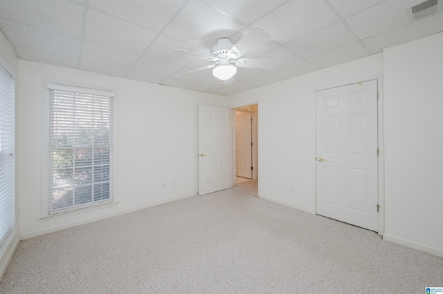 carpeted spare room featuring a paneled ceiling and ceiling fan