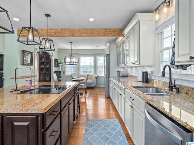 kitchen featuring black appliances, a kitchen island, white cabinetry, beamed ceiling, and sink