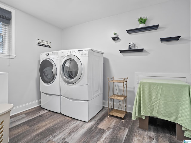 clothes washing area featuring washing machine and clothes dryer and dark hardwood / wood-style floors