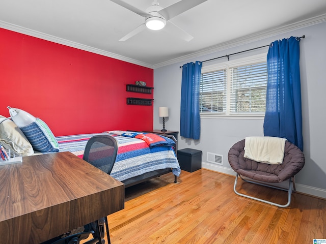 bedroom with ornamental molding, ceiling fan, and wood-type flooring