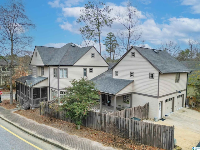 view of property exterior with a garage and a sunroom