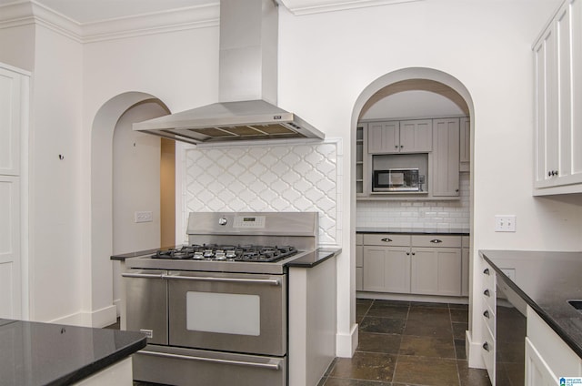 kitchen featuring island range hood, ornamental molding, double oven range, dark stone counters, and decorative backsplash