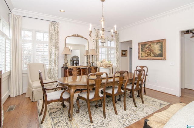 dining area featuring ornamental molding, a chandelier, and light hardwood / wood-style floors