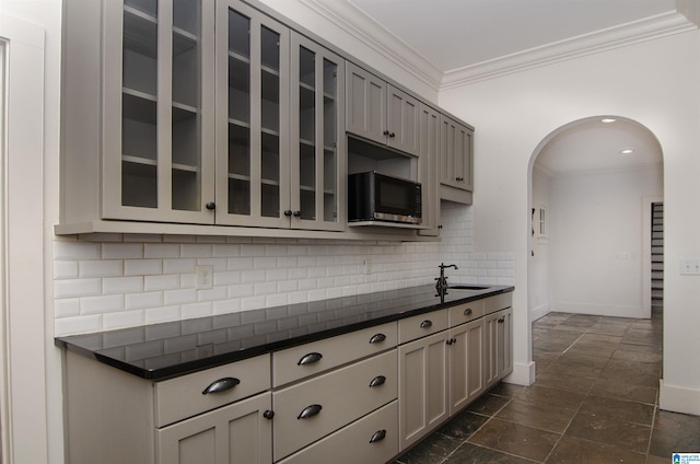 kitchen featuring tasteful backsplash, crown molding, gray cabinets, and sink