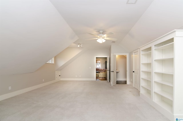 bonus room featuring vaulted ceiling, ceiling fan, light carpet, and built in features