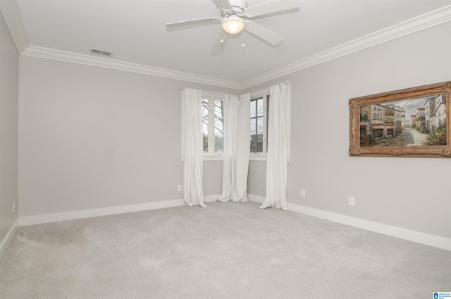 empty room featuring light carpet, crown molding, and ceiling fan