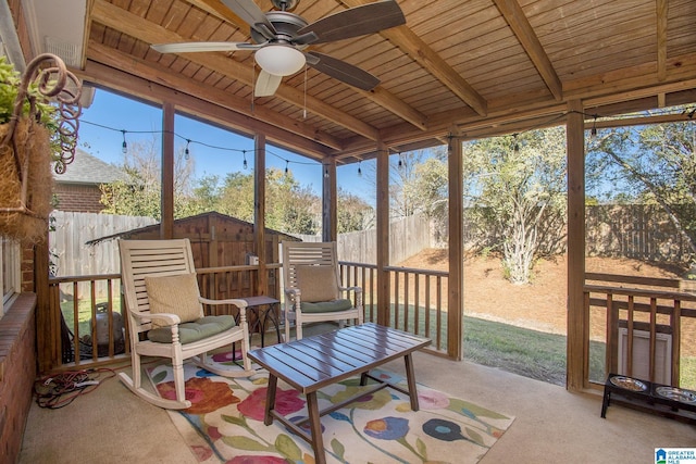 sunroom / solarium featuring ceiling fan, lofted ceiling with beams, and wood ceiling