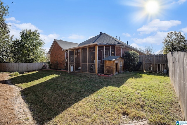 back of property with a sunroom and a lawn