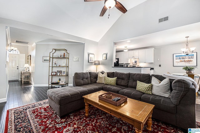 living room with ceiling fan with notable chandelier, high vaulted ceiling, and dark hardwood / wood-style floors