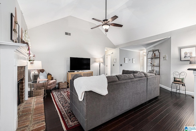 living room with ceiling fan, dark hardwood / wood-style flooring, a brick fireplace, and high vaulted ceiling