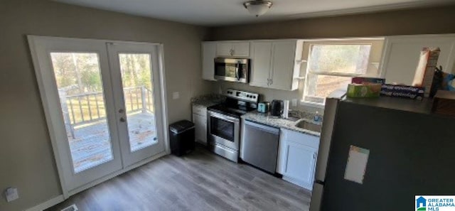 kitchen featuring appliances with stainless steel finishes, white cabinetry, french doors, and plenty of natural light