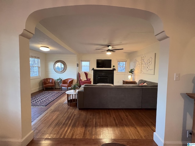 living room featuring ceiling fan, a fireplace, hardwood / wood-style floors, and plenty of natural light