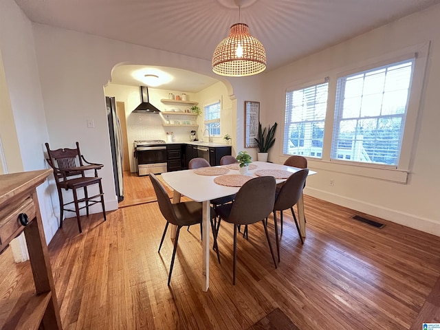 dining space with sink and light hardwood / wood-style flooring