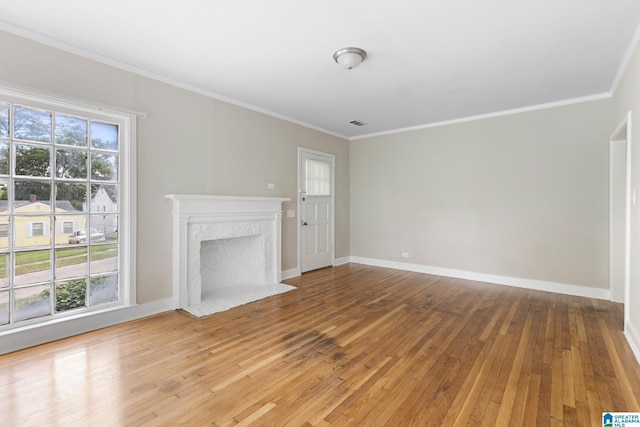 unfurnished living room with light hardwood / wood-style floors, crown molding, and a fireplace