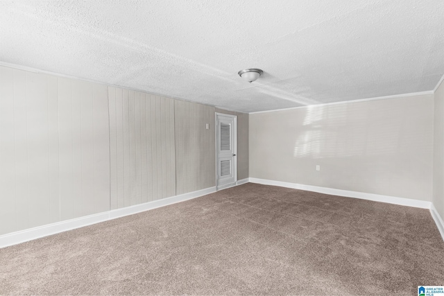 carpeted empty room with crown molding and a textured ceiling