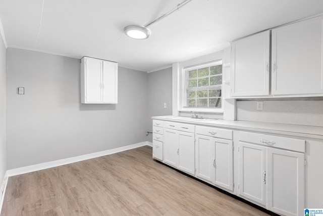 kitchen featuring white cabinetry, sink, and light hardwood / wood-style flooring